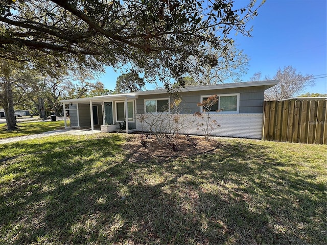 ranch-style house with fence, a front lawn, and brick siding