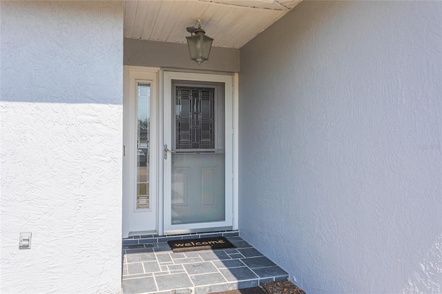 view of exterior entry with stucco siding