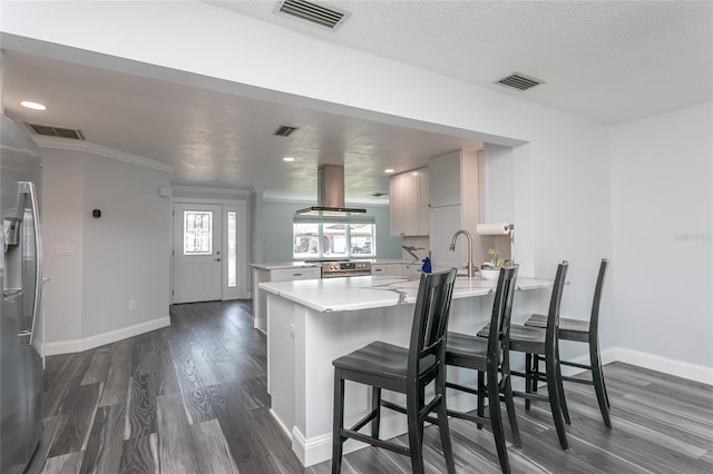 kitchen with visible vents, a peninsula, and dark wood-style flooring