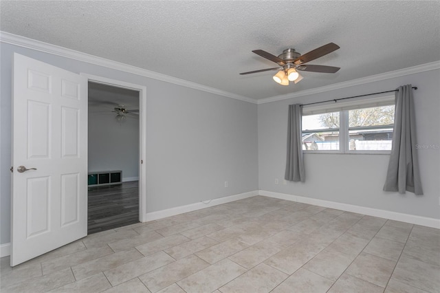 unfurnished room featuring baseboards, a textured ceiling, and ornamental molding