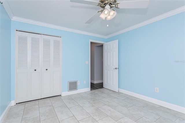 unfurnished bedroom featuring baseboards, visible vents, a closet, and ornamental molding