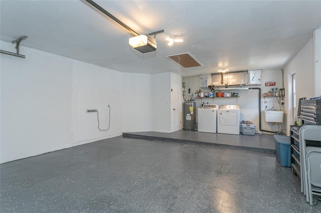 garage featuring washer and clothes dryer, electric water heater, a garage door opener, and a sink