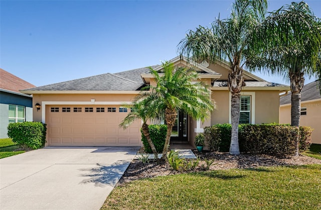 view of front of property featuring concrete driveway, a garage, a front yard, and stucco siding