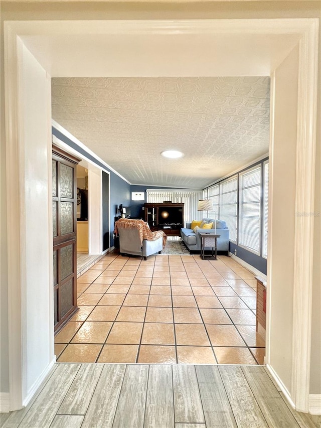 unfurnished living room with light tile patterned floors and baseboards