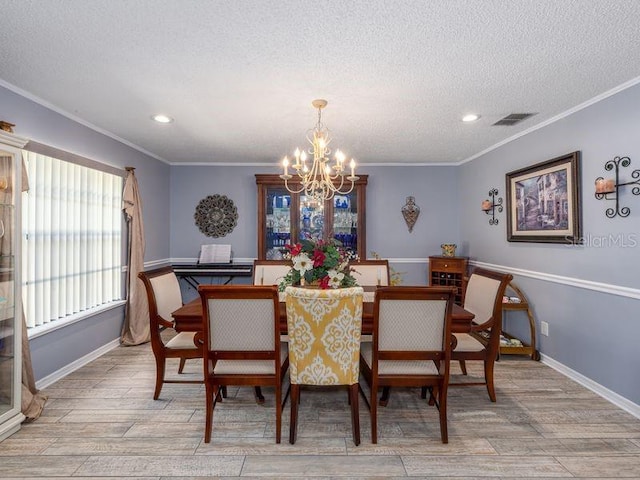 dining area with a chandelier, visible vents, crown molding, and light wood-type flooring