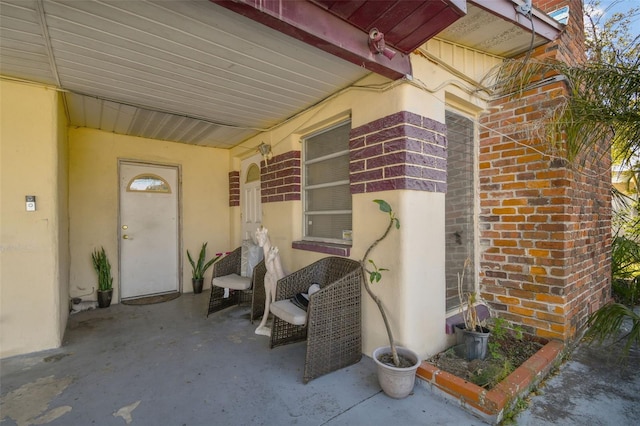 doorway to property featuring brick siding