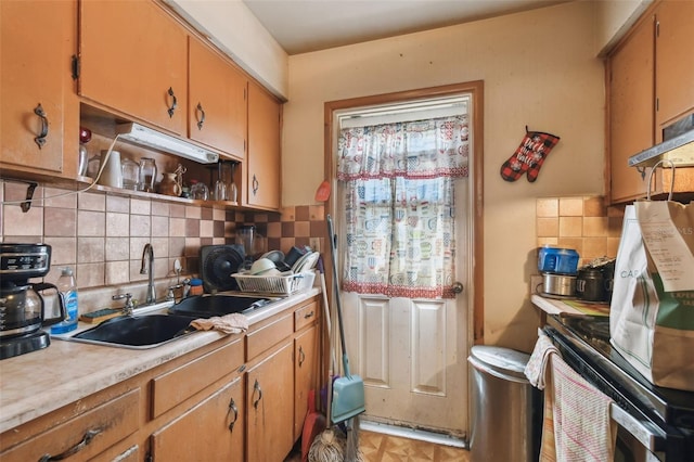 kitchen with open shelves, backsplash, light countertops, and a sink