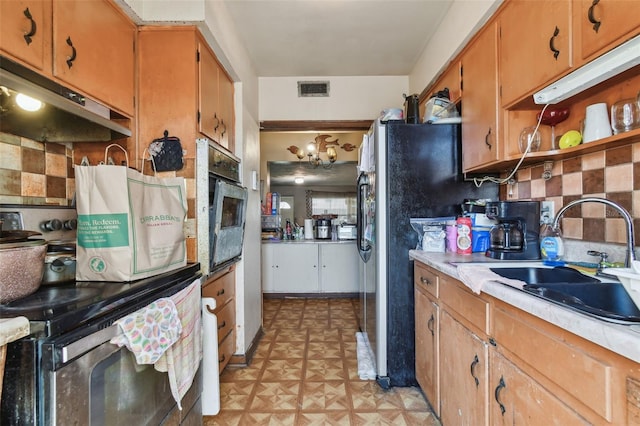 kitchen featuring light floors, light countertops, visible vents, wall oven, and a sink