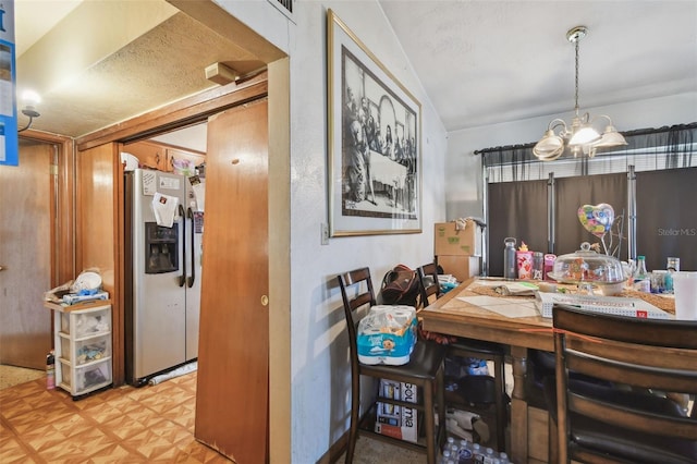 dining area with lofted ceiling, an inviting chandelier, and tile patterned floors