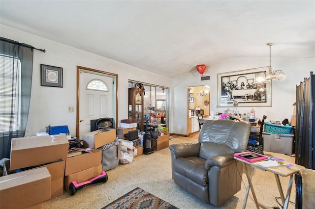 living area with visible vents, vaulted ceiling, a notable chandelier, and speckled floor