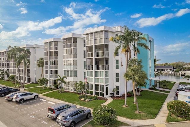 view of property featuring uncovered parking and a water view