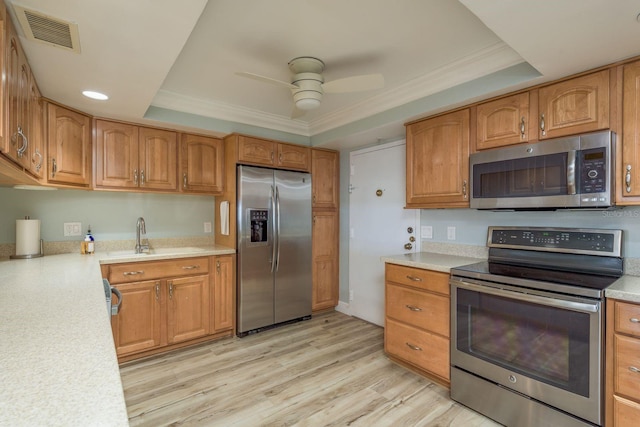 kitchen featuring a tray ceiling, visible vents, light wood-style flooring, appliances with stainless steel finishes, and a sink