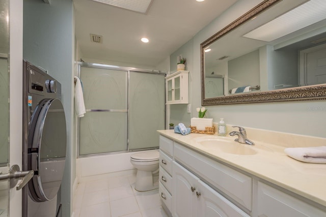 bathroom with toilet, vanity, visible vents, tile patterned floors, and washer / dryer