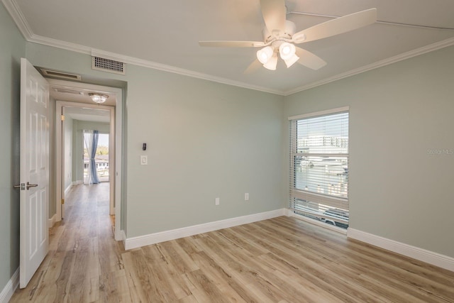 unfurnished room with light wood-style flooring, visible vents, a ceiling fan, baseboards, and ornamental molding