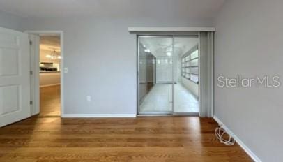 spare room featuring wood finished floors and baseboards