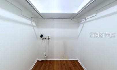 interior space featuring laundry area, dark wood finished floors, and baseboards