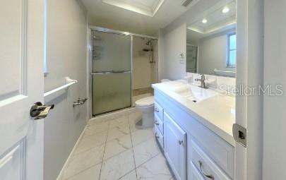 full bath with toilet, marble finish floor, vanity, and a stall shower