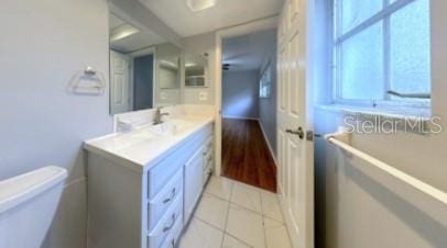 half bathroom featuring vanity, toilet, and tile patterned floors