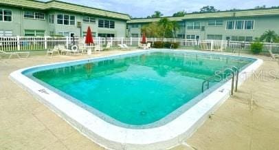 pool featuring a patio area and fence