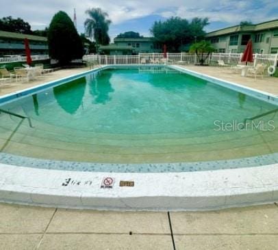 pool featuring fence and a patio