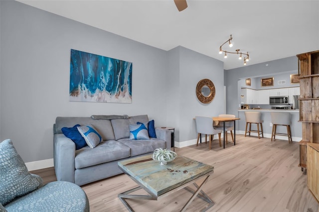 living room with light wood-type flooring and baseboards