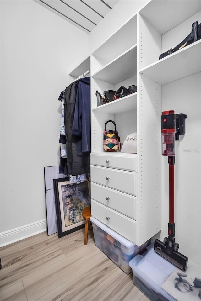 walk in closet with light wood-style flooring