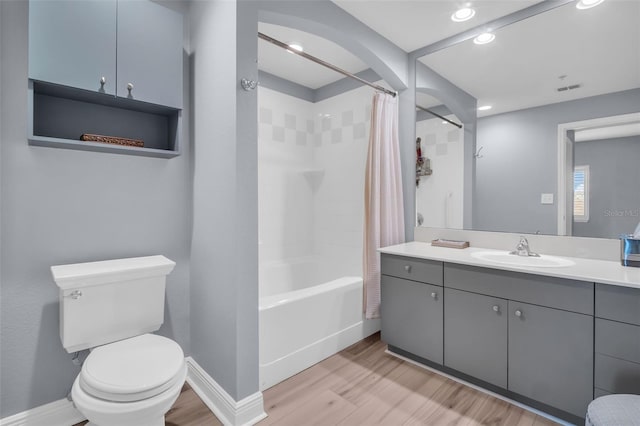 full bath featuring vanity, wood finished floors, visible vents, shower / bath combo with shower curtain, and toilet