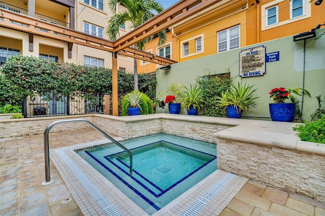 view of swimming pool featuring a hot tub