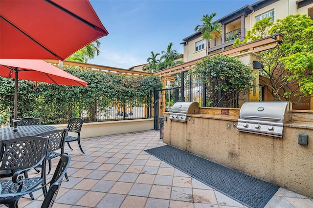 view of patio / terrace featuring grilling area, fence, outdoor dining area, and area for grilling