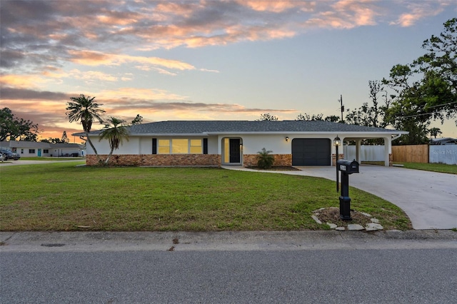 ranch-style home featuring a garage, brick siding, fence, driveway, and a lawn