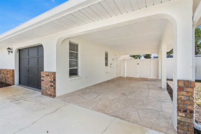 view of patio / terrace featuring a gate, fence, and concrete driveway