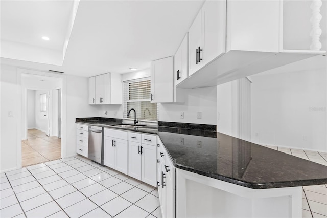 kitchen with light tile patterned floors, stainless steel dishwasher, a sink, and white cabinets