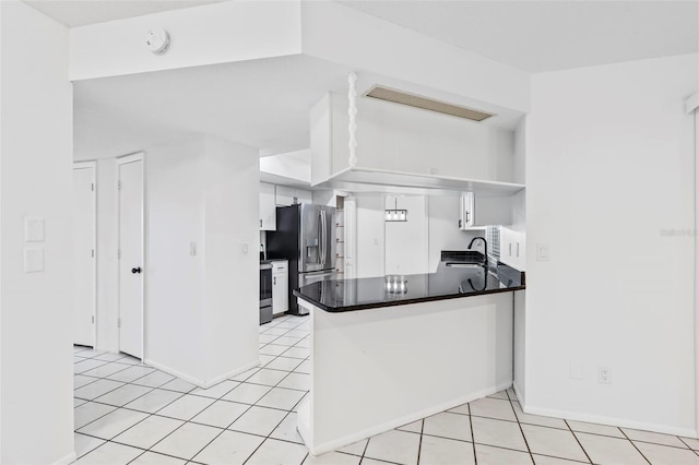 kitchen featuring a peninsula, appliances with stainless steel finishes, a sink, and white cabinetry