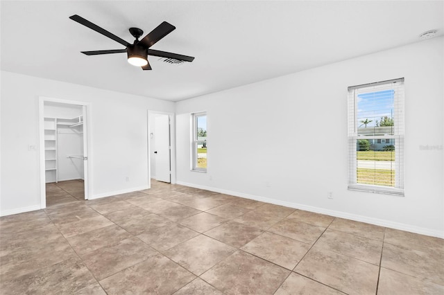 empty room featuring ceiling fan, baseboards, and light tile patterned floors