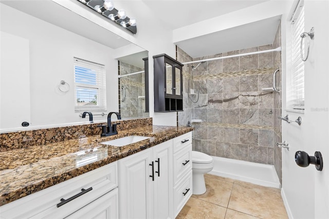 bathroom with a stall shower, vanity, toilet, and tile patterned floors