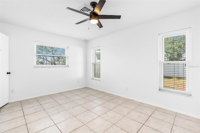 spare room featuring a ceiling fan and baseboards