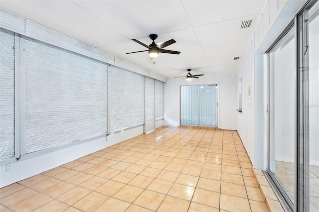 empty room with light tile patterned floors, ceiling fan, and visible vents