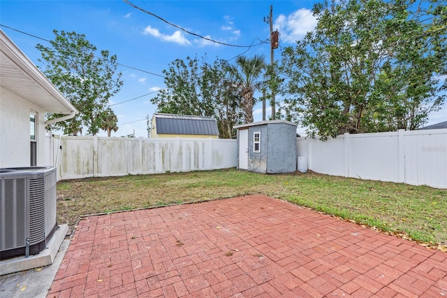 view of patio with an outbuilding, central AC unit, a fenced backyard, and a storage unit