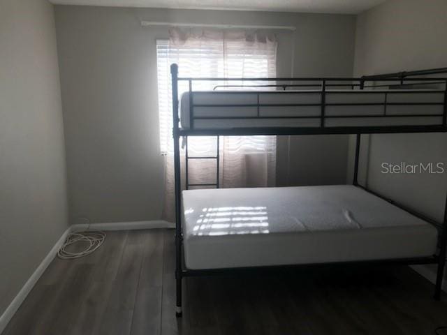 unfurnished bedroom featuring baseboards and wood finished floors