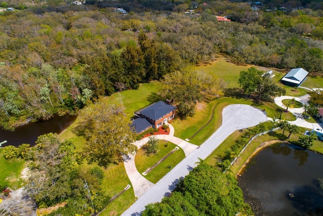 aerial view with a water view and a wooded view