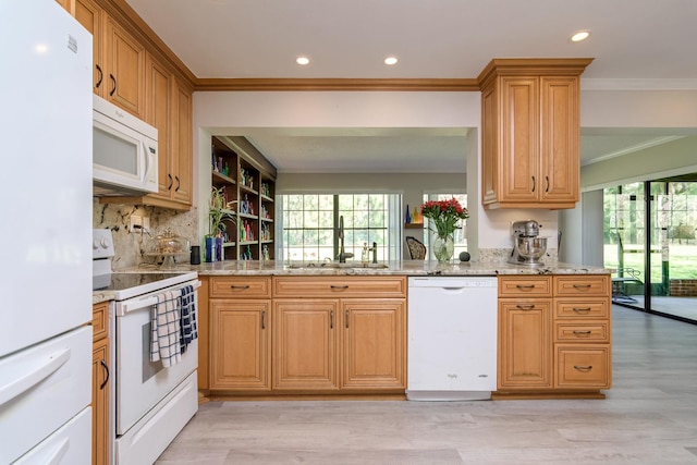 kitchen featuring ornamental molding, plenty of natural light, white appliances, and a sink