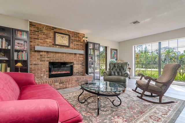 living room featuring a fireplace, visible vents, and wood finished floors