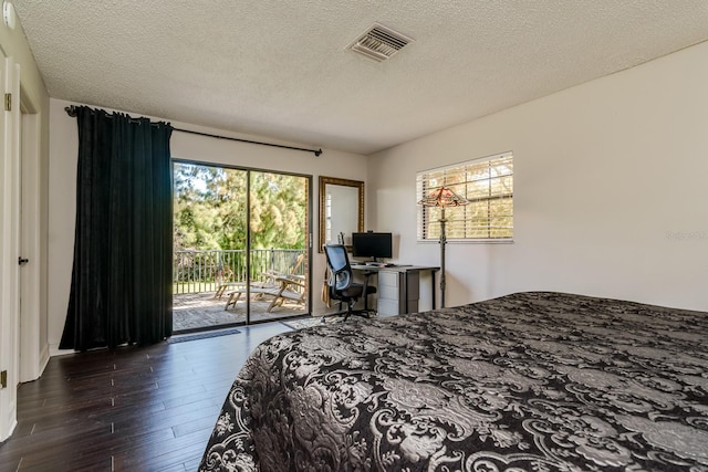 bedroom with access to outside, visible vents, a textured ceiling, and wood finished floors