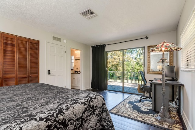 bedroom featuring a textured ceiling, access to outside, wood finished floors, and visible vents