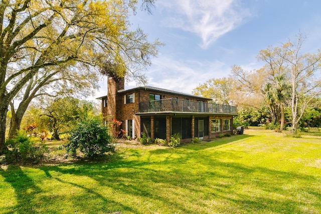 back of house with a yard, brick siding, and a chimney
