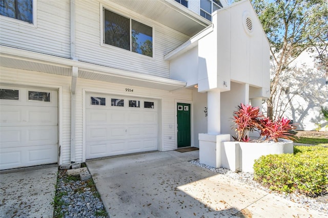 doorway to property with a garage and concrete driveway