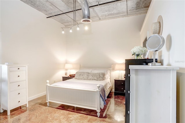 bedroom with concrete floors and baseboards