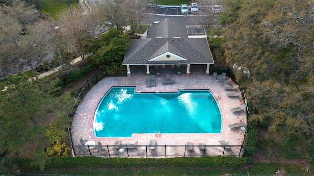 community pool featuring an outbuilding, an exterior structure, a patio area, and fence