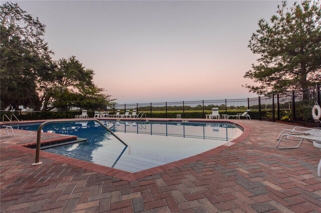 community pool with a patio area and fence