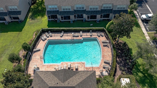 pool featuring a lawn and fence